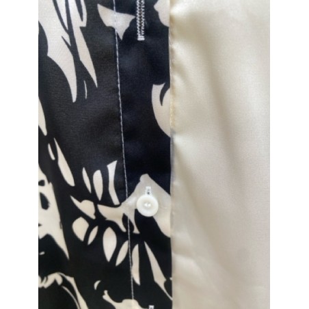 Chemisier femme noir et blanc à effet satiné, imprimé floral chic. Tissu fluide et élégant, parfait pour un look sophistiqué